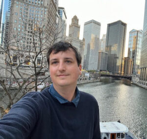 Selfie of a man with city skyscrapers behind him