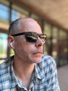 Photograph of a man wearing sunglasses. 
